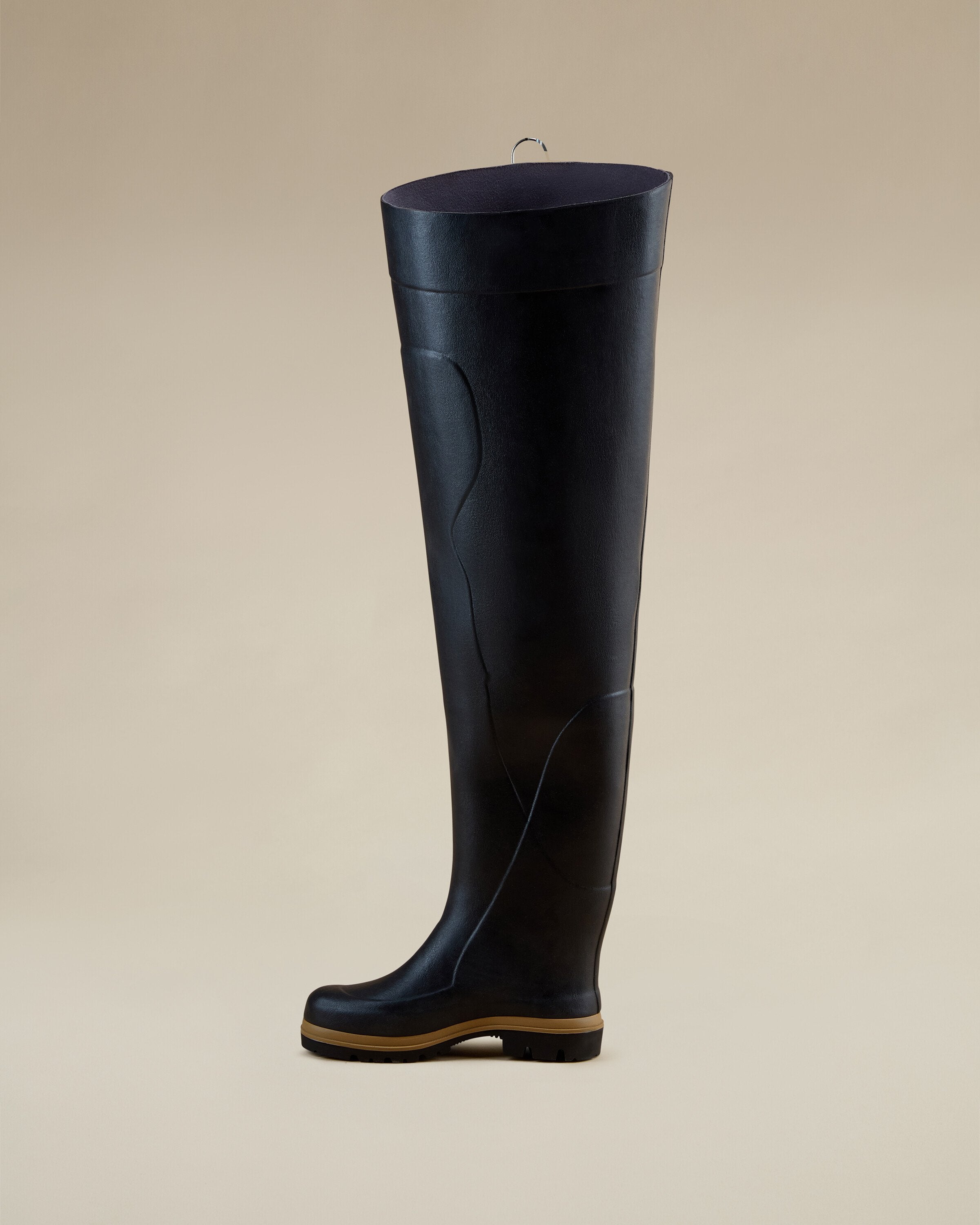 Rear-side profile of the Men's Océane Ponti Lined Thigh Boot in Black, with a gum-colored sole and sleek upper construction. Photographed in a neutral setting for product display.