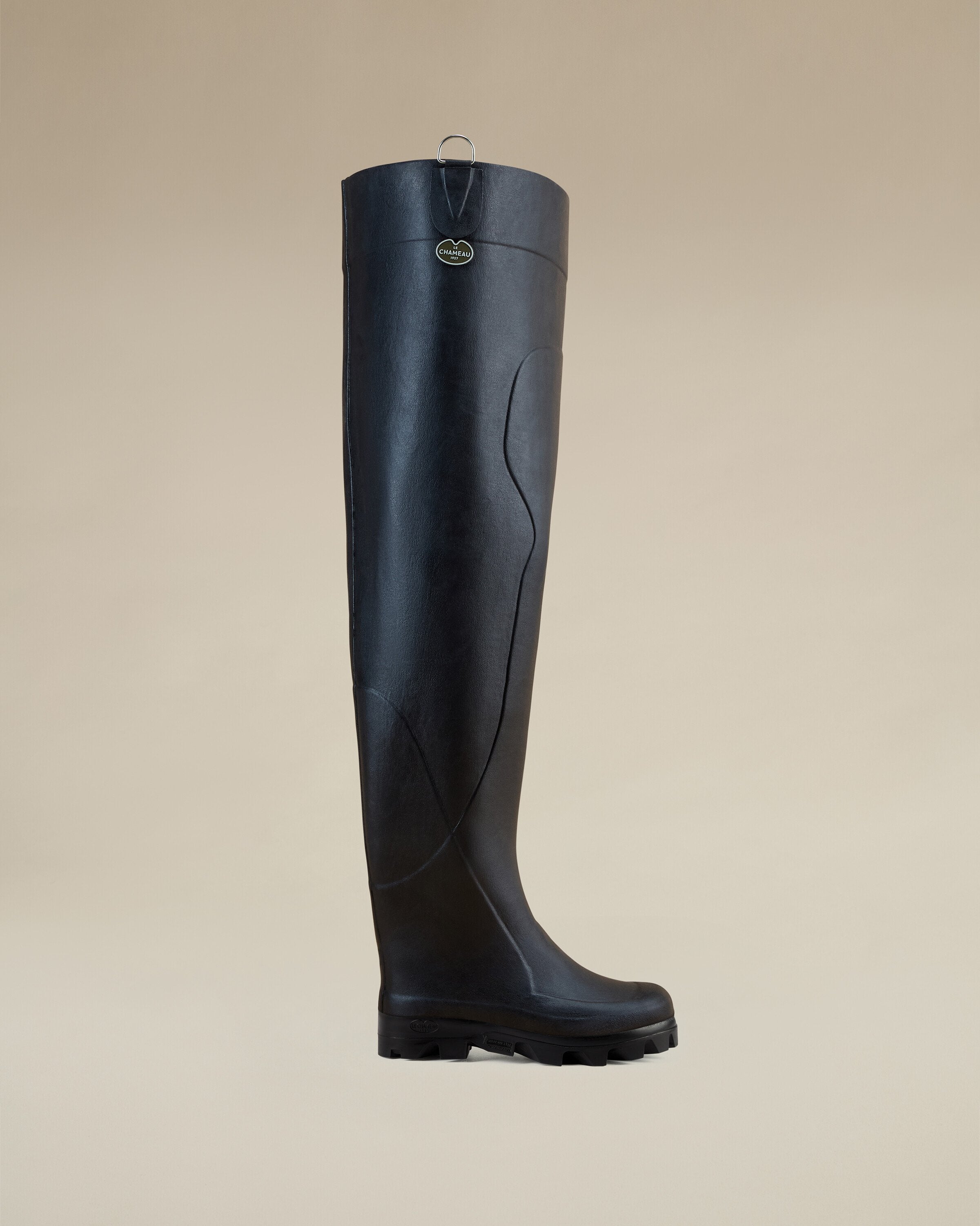 Product image of the Men's Océane Ponti Lined Thigh Boot in Black, viewed from the left side. The boot is displayed in a simple studio setting with beige background, showing its height and solid black exterior.