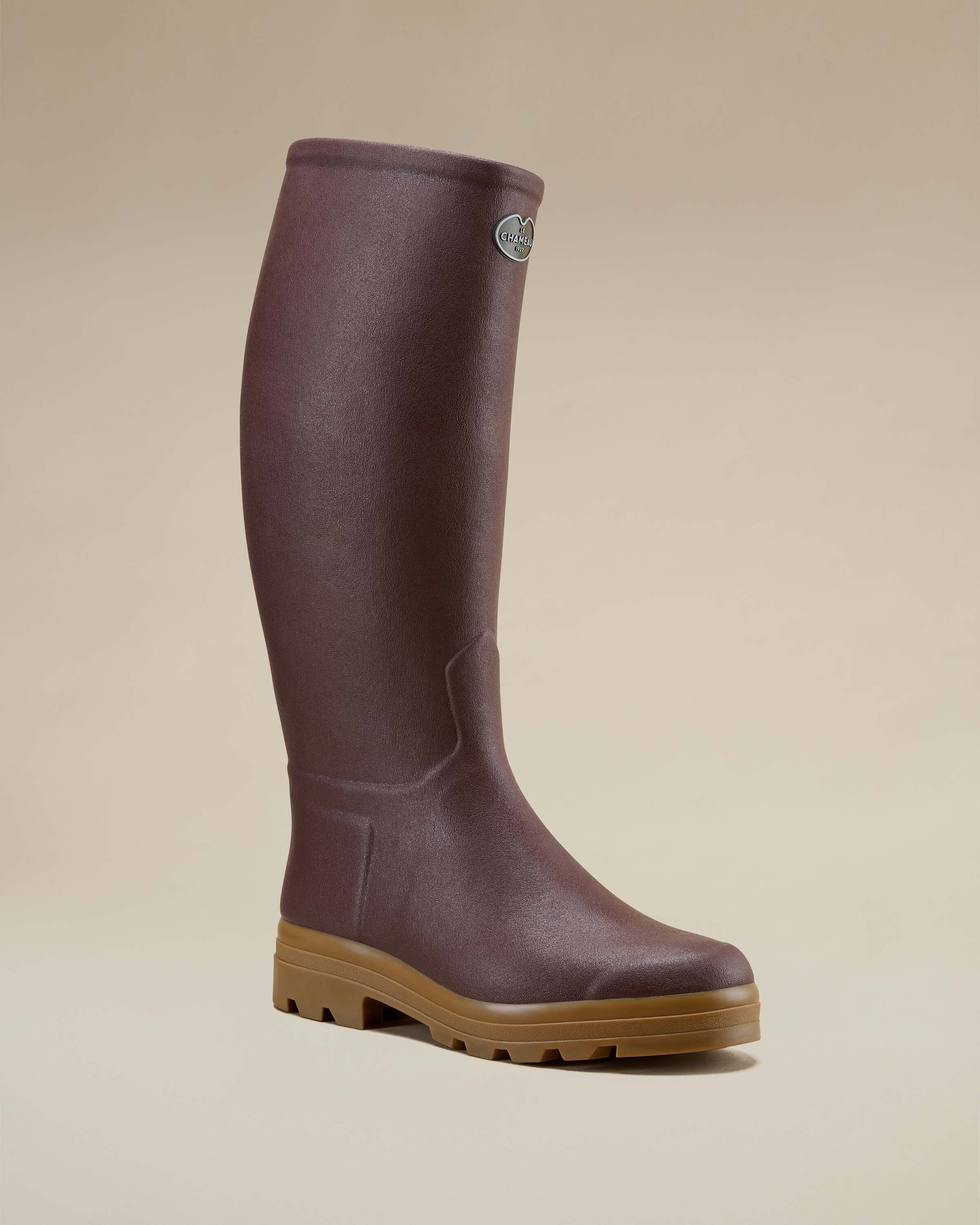 A single Men's Saint Hubert Leather Lined Wellington Boot in Brown angled slightly forward to show the front and outer side. The internal white leather lining peeks from the top edge, and the embossed logo badge is visible near the top rim.