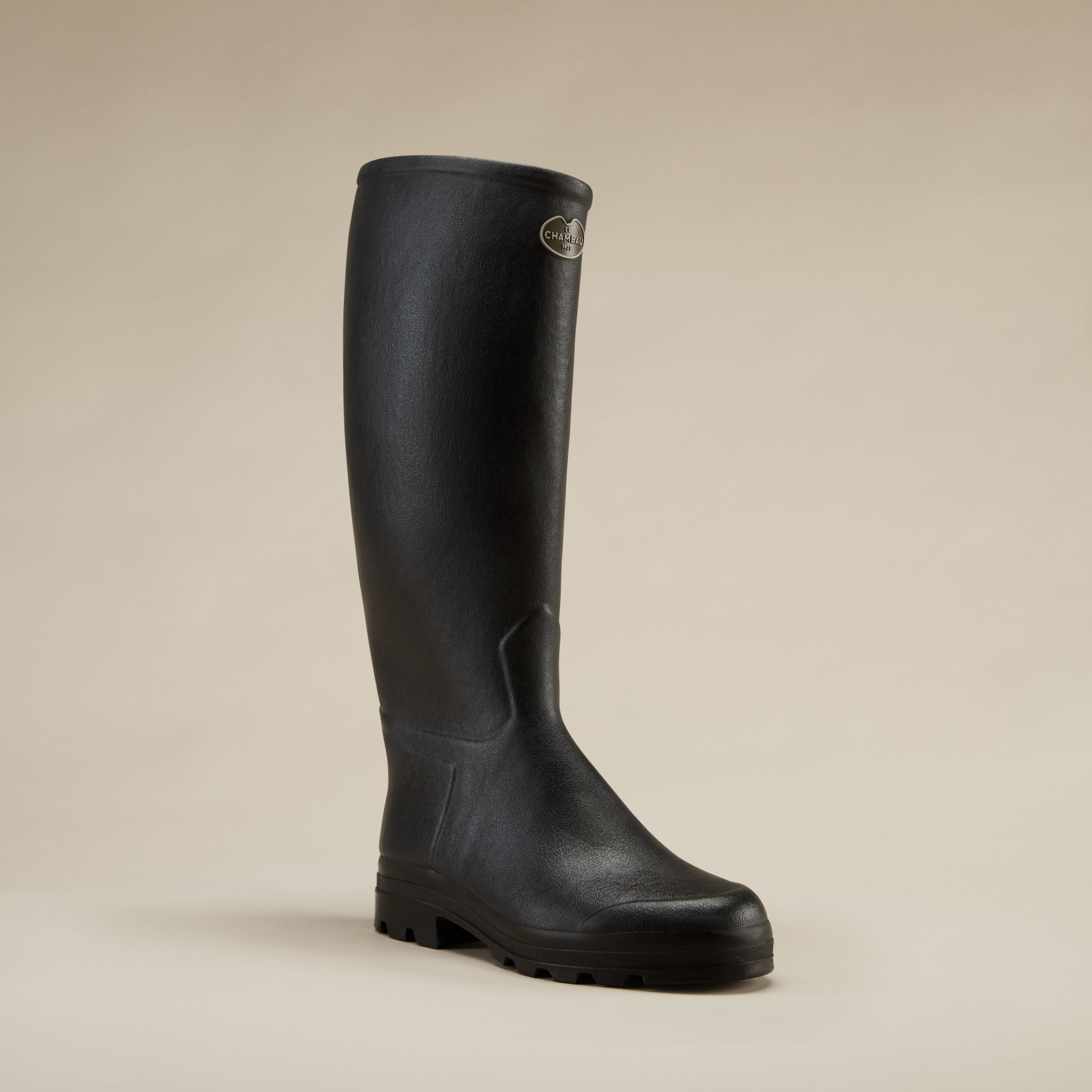 A dynamic three-quarter angle view of a single Men's Saint Hubert Leather Lined Wellington Boot in Black, slightly turned to the right. This shot emphasises the elegant curvature and practical sole design of the boot.