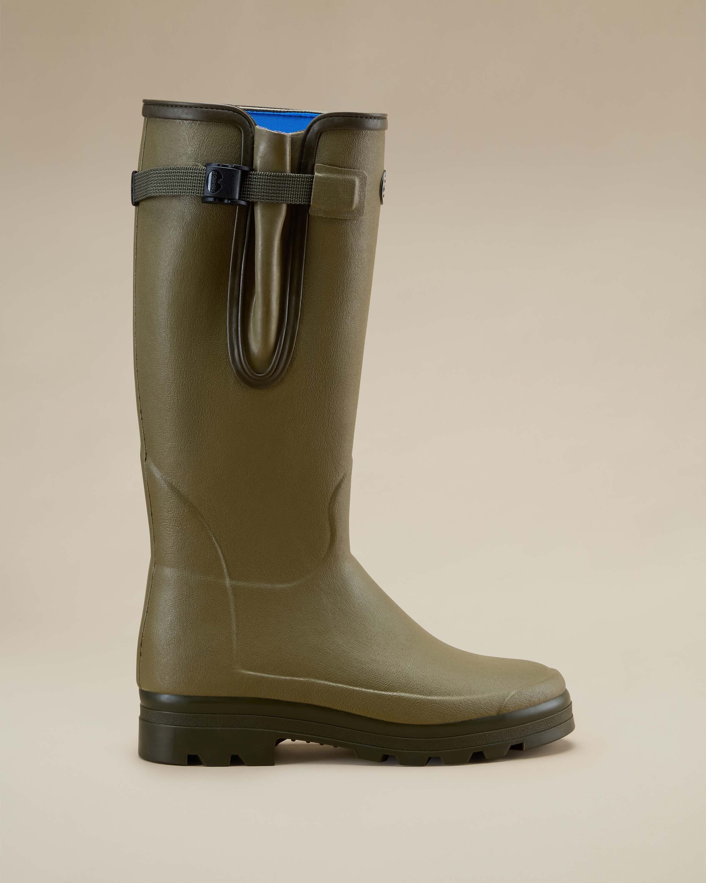 Close-up side profile of a single Men's Vierzonord Neoprene Lined Wellington Boot in Iconic Green on a beige background. The image highlights the gusset strap system and the subtle detailing of the rubber overlay around the heel and ankle.
