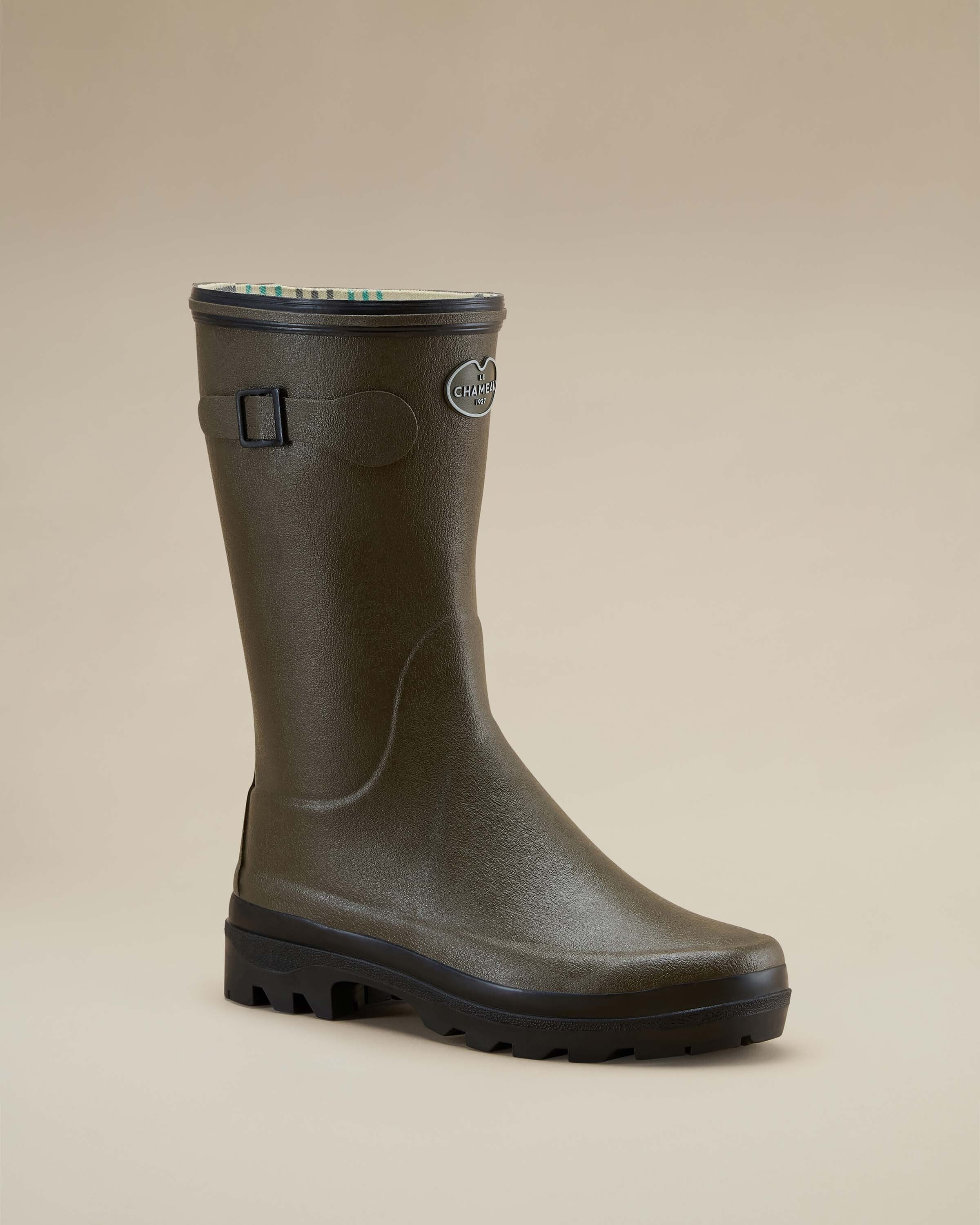 Single Women's Giverny Jersey Lined Bottillon in Chameau Green angled to show both front and side contours. Displayed on a beige background, the boot’s logo and decorative strap are prominently visible.