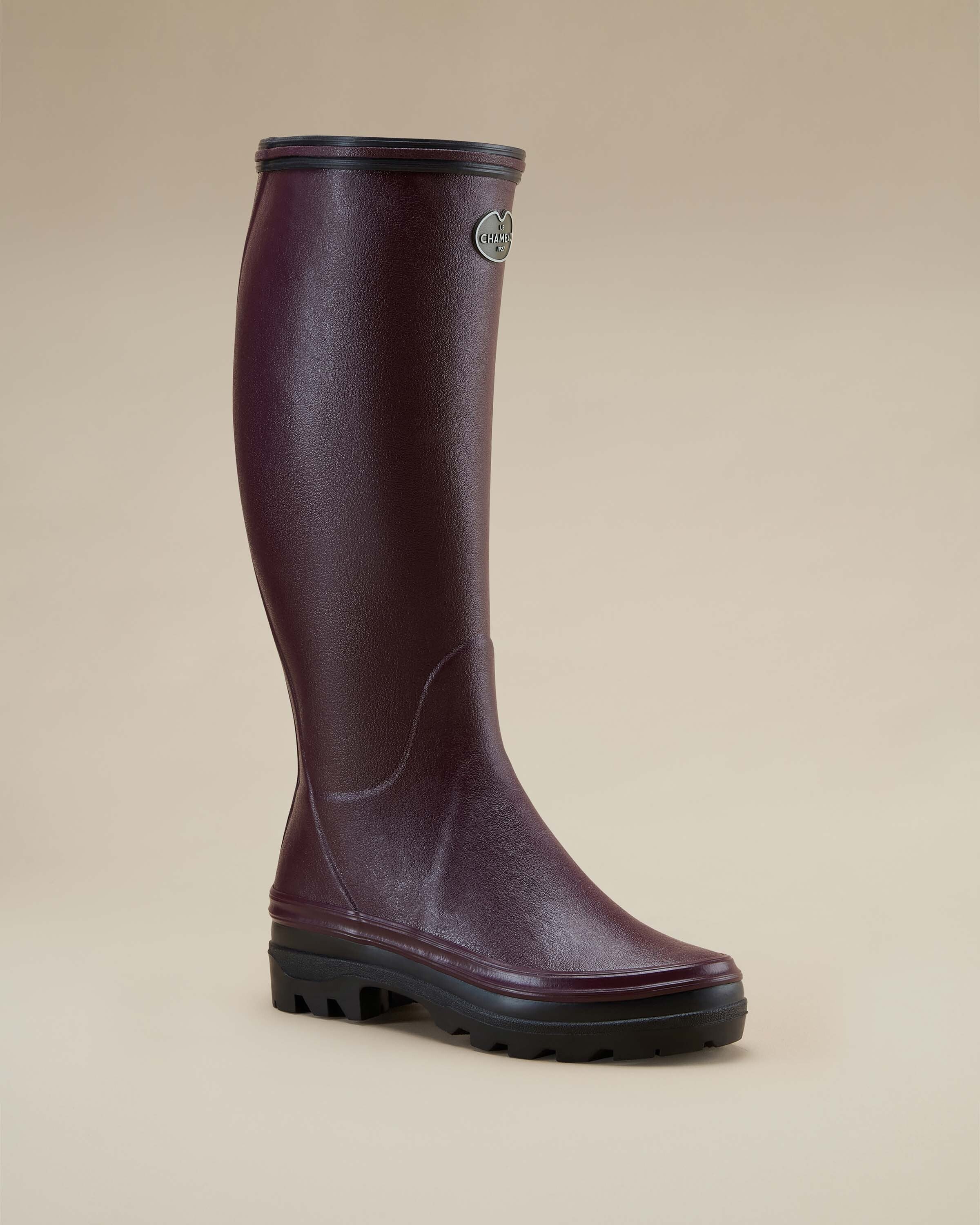 Single Women's Giverny Jersey Lined Wellington Boot in Cherry Red angled to the right, displaying both the front and outer side contours. The boot is photographed on a beige background with the metal logo badge visible on the outer shaft.