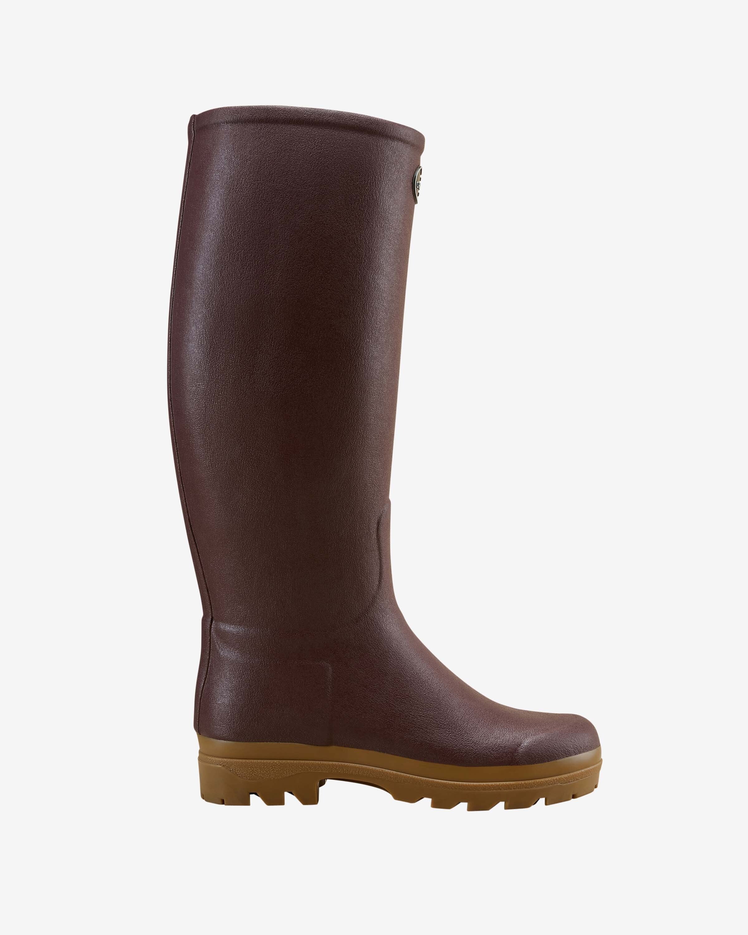 A single Women's Saint Hubert Leather Lined Wellington Boot in Brown displayed in full side profile. The boot features a sleek, minimalist design with a subtle textured rubber finish and a tan lug sole, photographed against a clean white background.