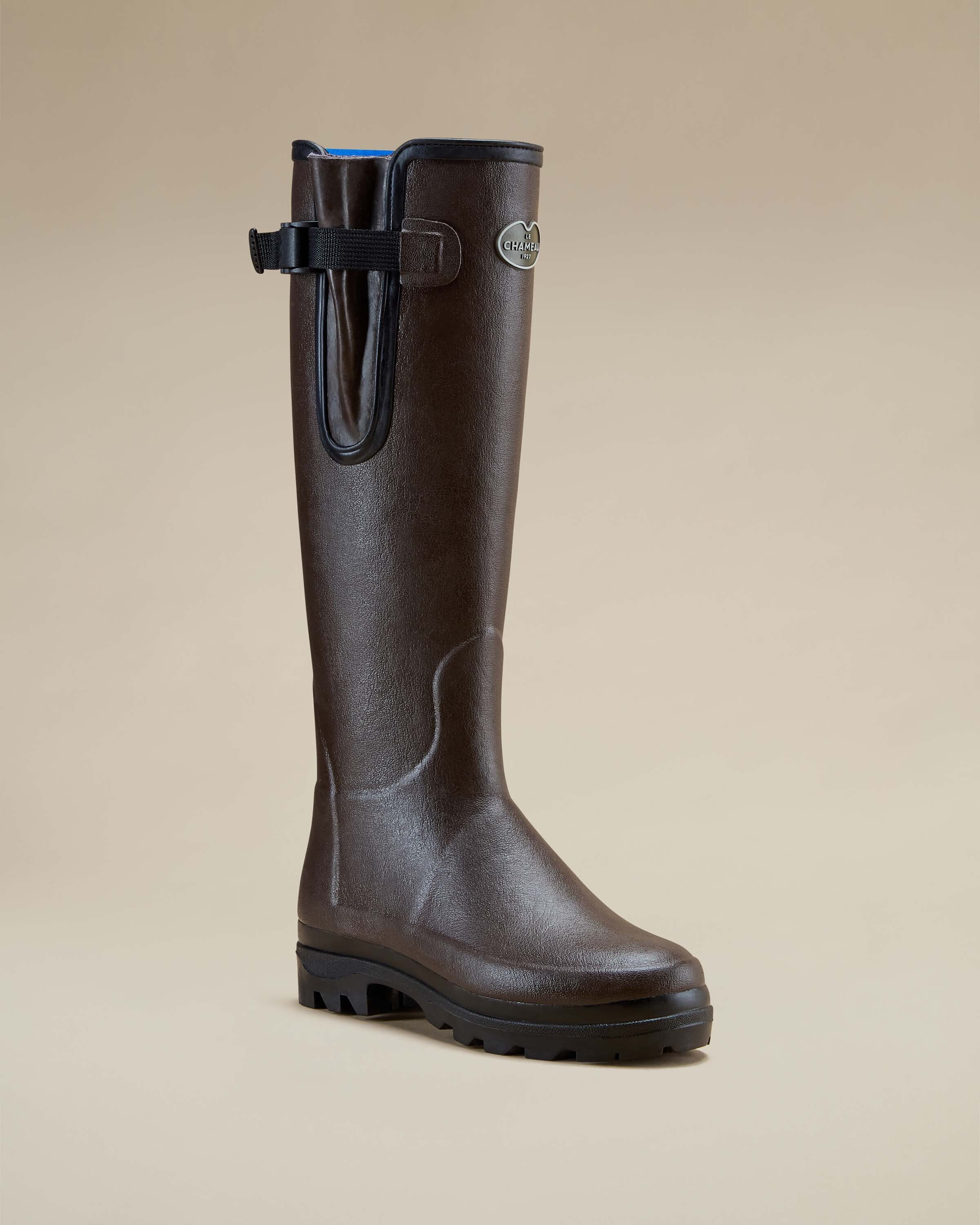 A single Women's Vierzonord Neoprene Lined Wellington Boot in Dark Brown angled slightly to the right, presented on a light tan background. This image showcases the boot’s refined toe box, contoured calf structure, and robust black rubber outsole with deep traction ridges. The clean lines and muted matte finish reflect the brand’s heritage and utilitarian functionality.