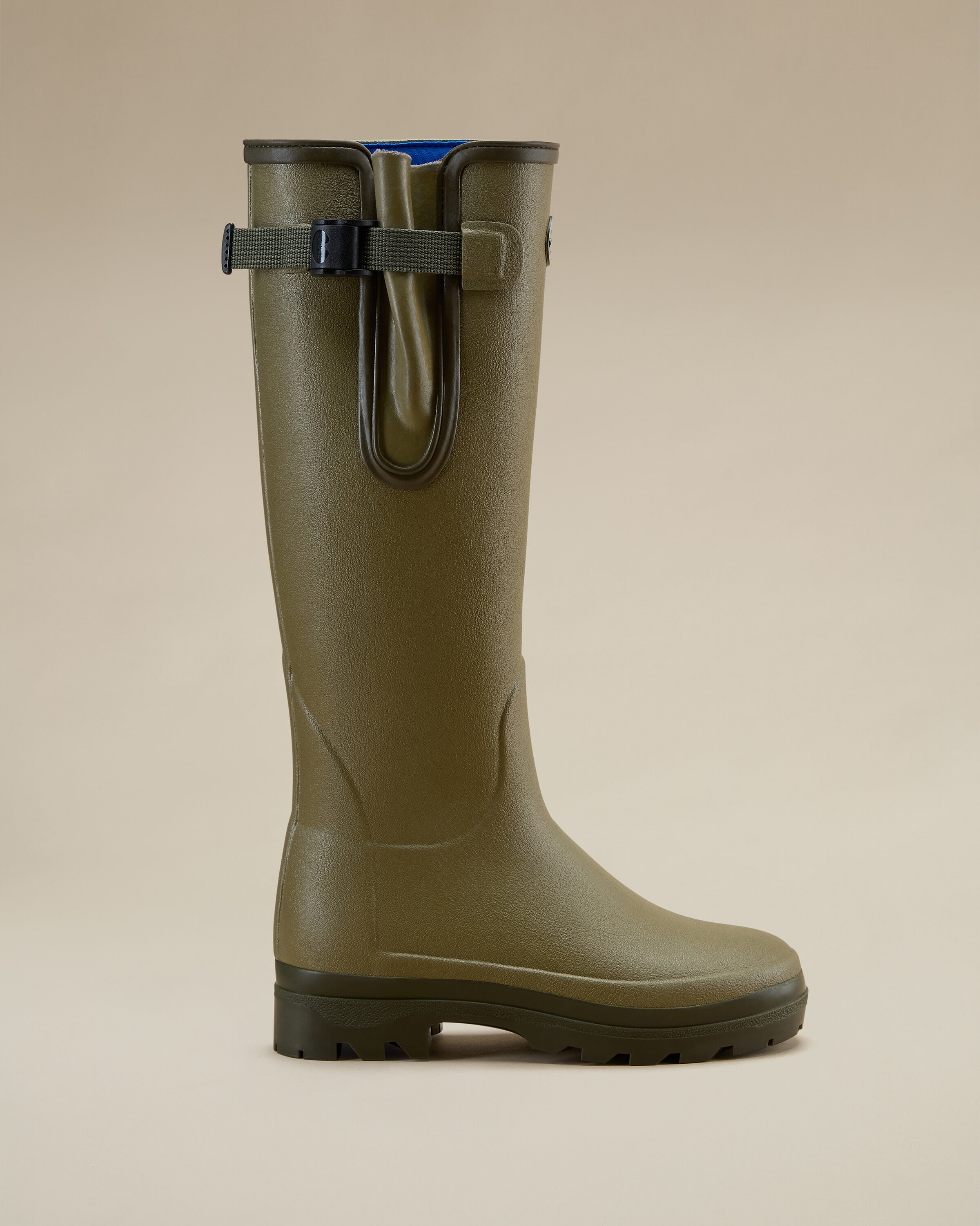 A dynamic close-up of the Women's Vierzonord Neoprene Lined Wellington Boot in Iconic Green soles, showing one boot resting on top of another. The chunky, all-terrain tread pattern is clearly visible, designed for superior grip in wet and muddy conditions. The camera angle emphasises the sculpted sole and heel drop.