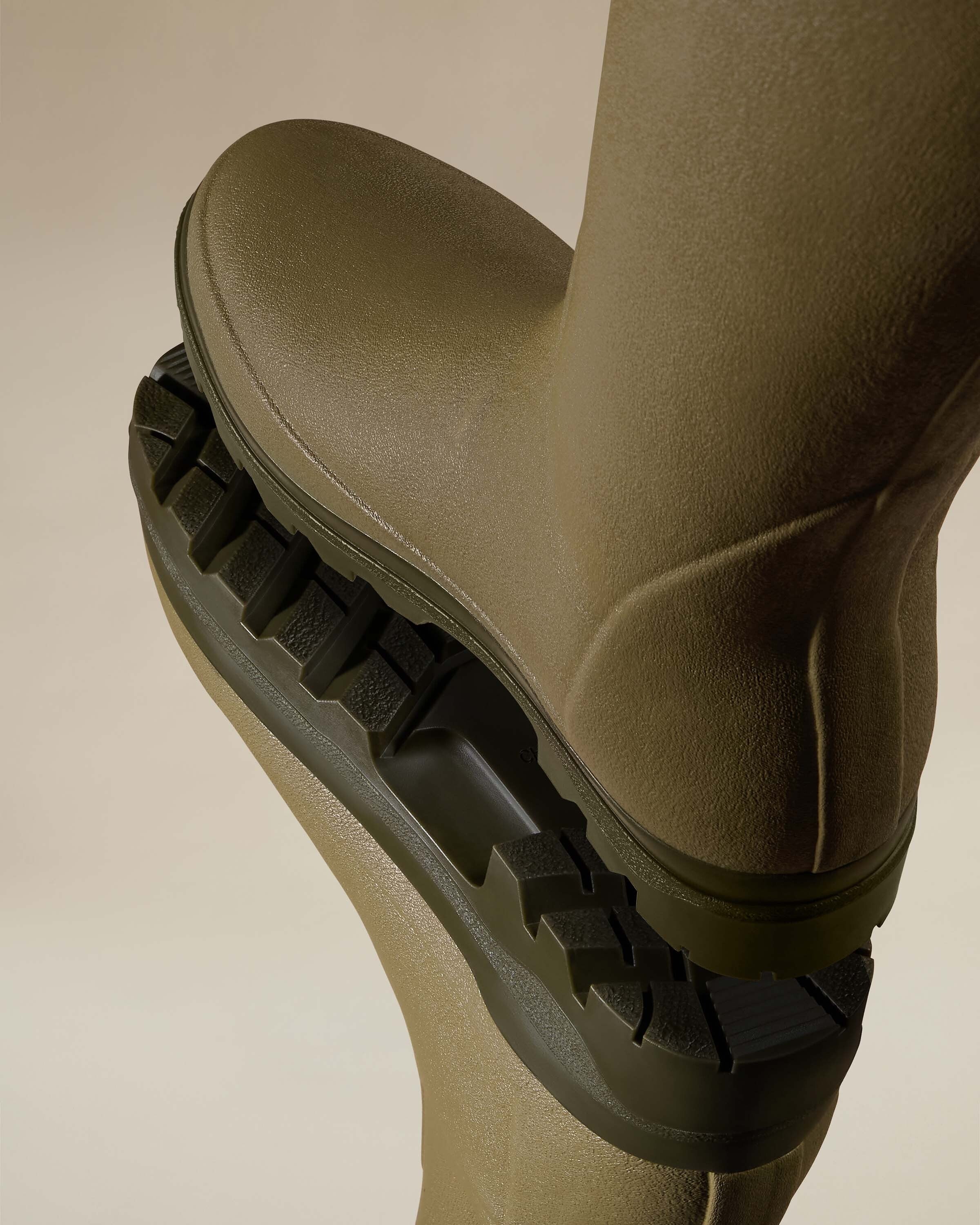A close-up detail shot of the upper shaft of the Women's Vierzonord Neoprene Lined Wellington Boot in Iconic Green, clearly showing the adjustable gusset with green webbing, the molded rubber gusset loop, and the bright blue neoprene lining, indicating thermal insulation and comfort.