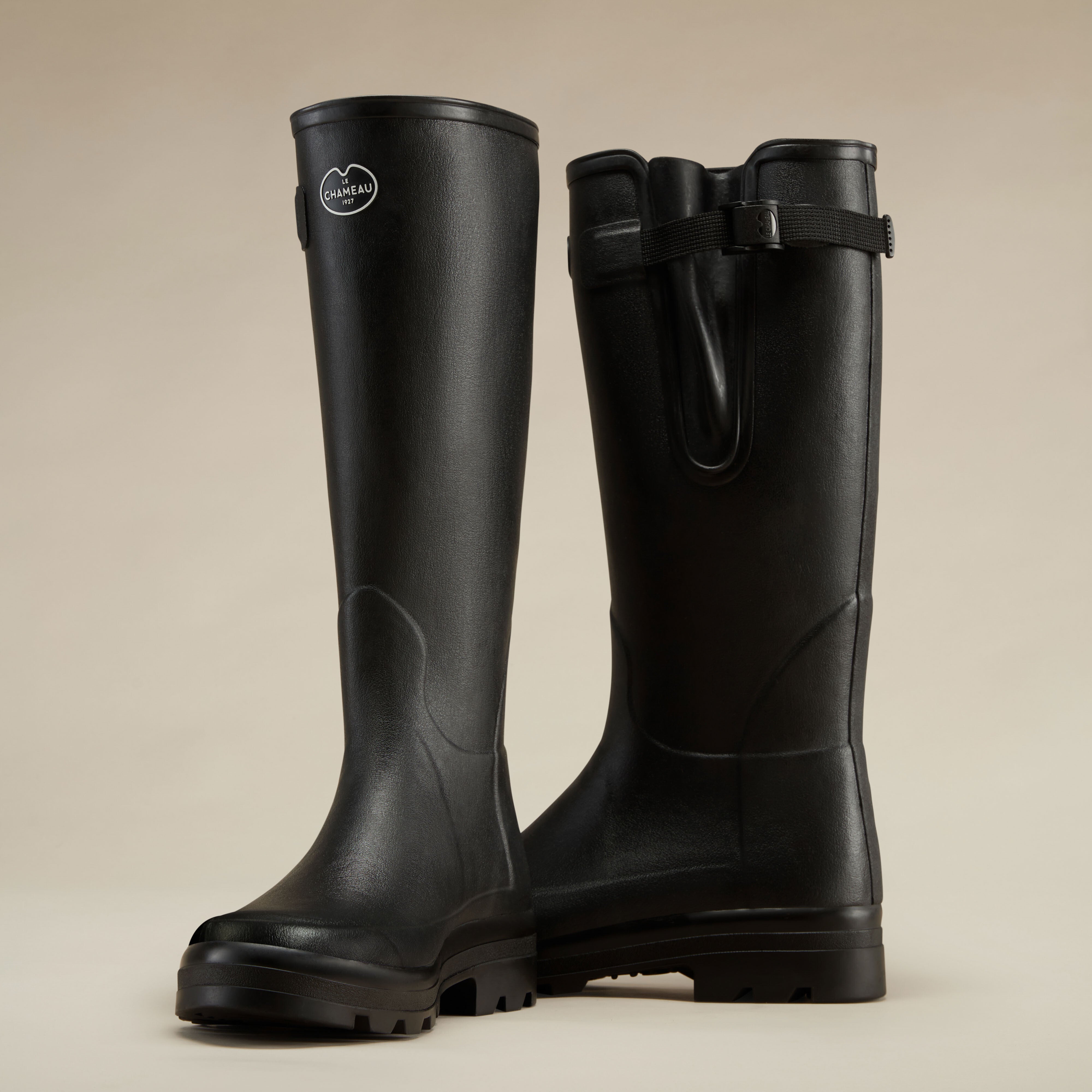 Back angled pair view of the Men's Vierzonord Neoprene Lined Wellington Boot in Black, emphasizing the adjustable gusset system with the strap fully extended. This view showcases the structured silhouette and reinforced heel areas for durability.