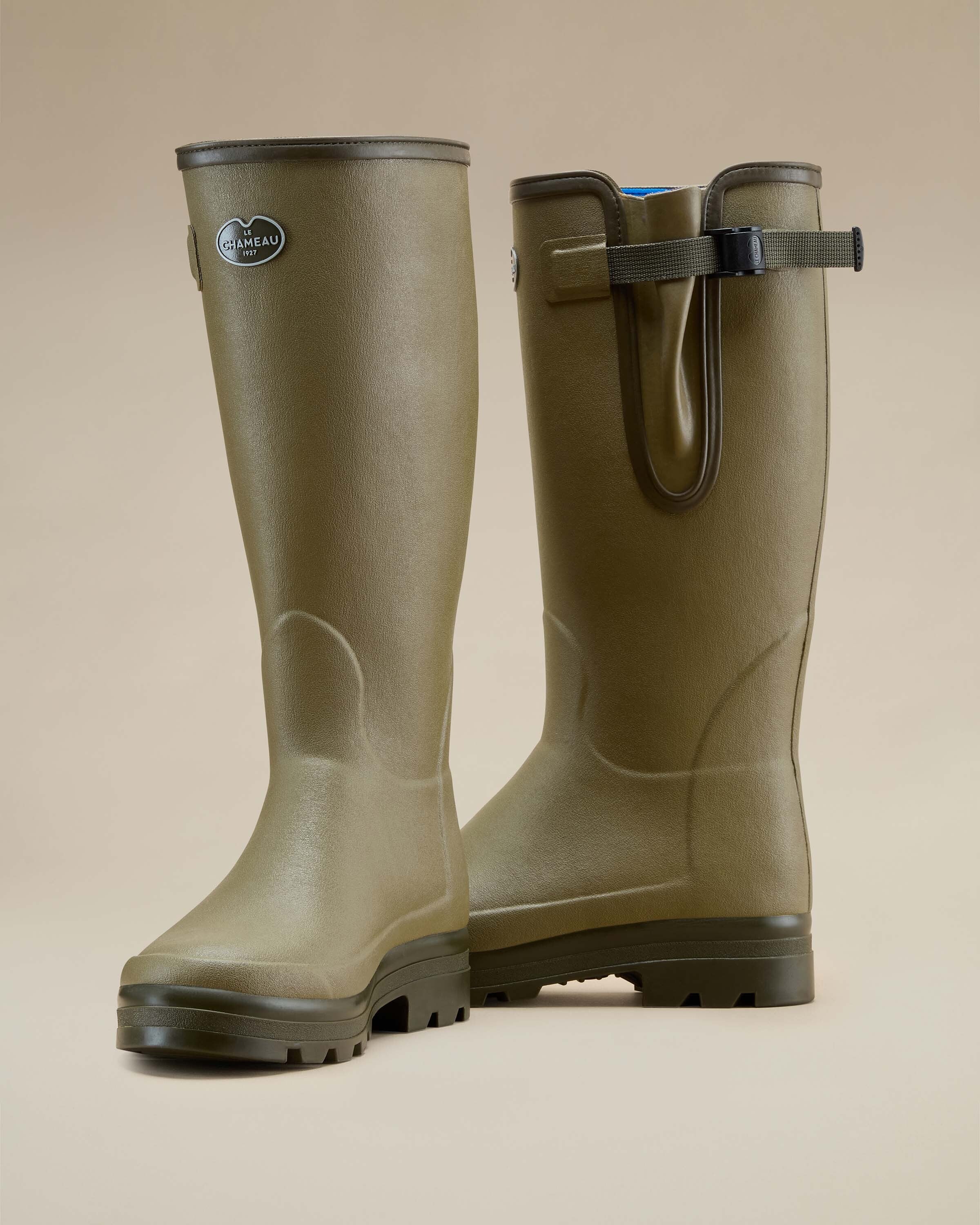 Back angle view of a pair of Men's Vierzonord Neoprene Lined Wellington Boot in Iconic Green on a neutral beige background. This perspective emphasises the rear gusset adjustment strap, contoured shaping for calf fit, and molded heels for structural support.