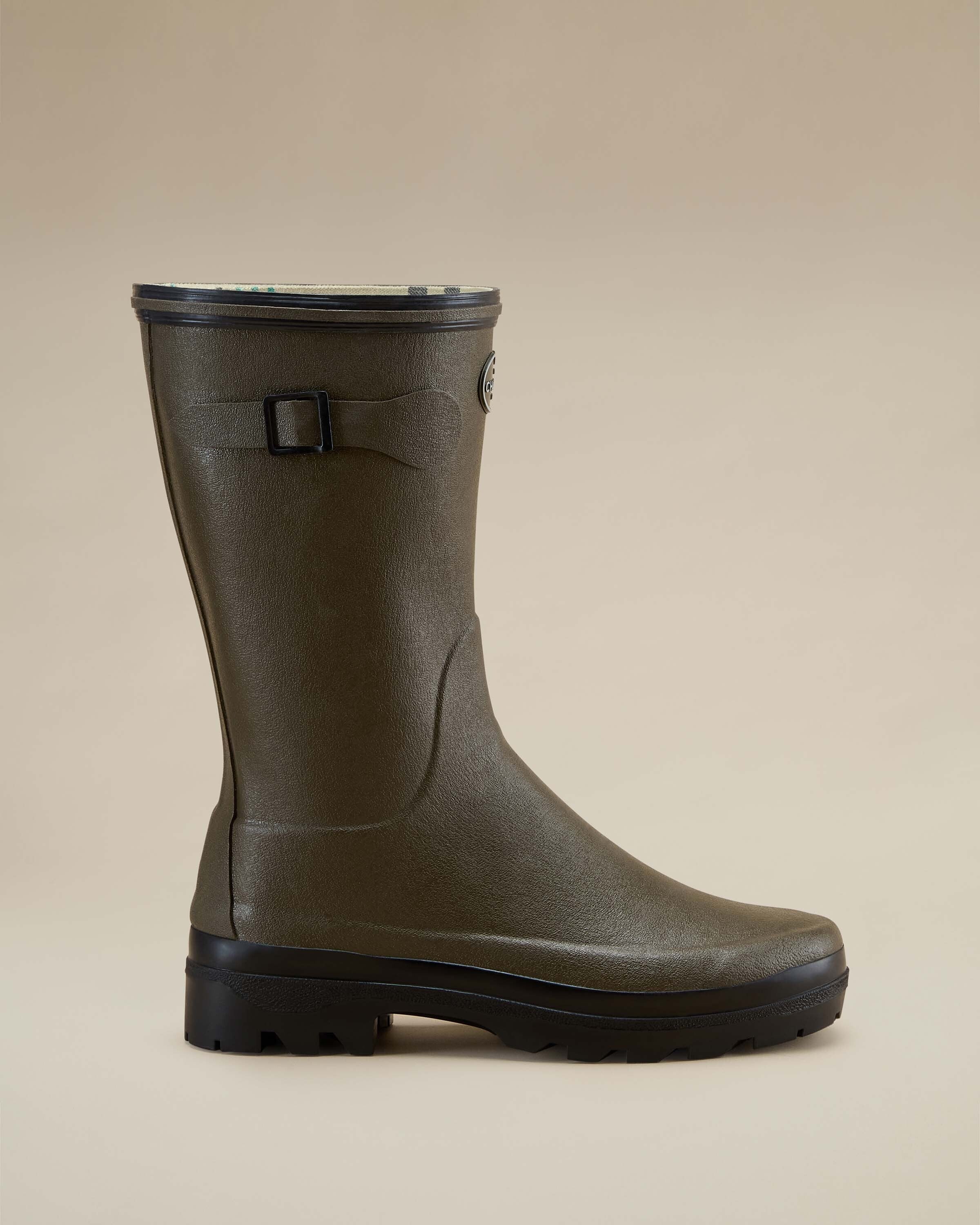 Single Women's Giverny Jersey Lined Bottillon in Chameau Green angled to show both front and side contours. Displayed on a beige background, the boot’s logo and decorative strap are prominently visible.
