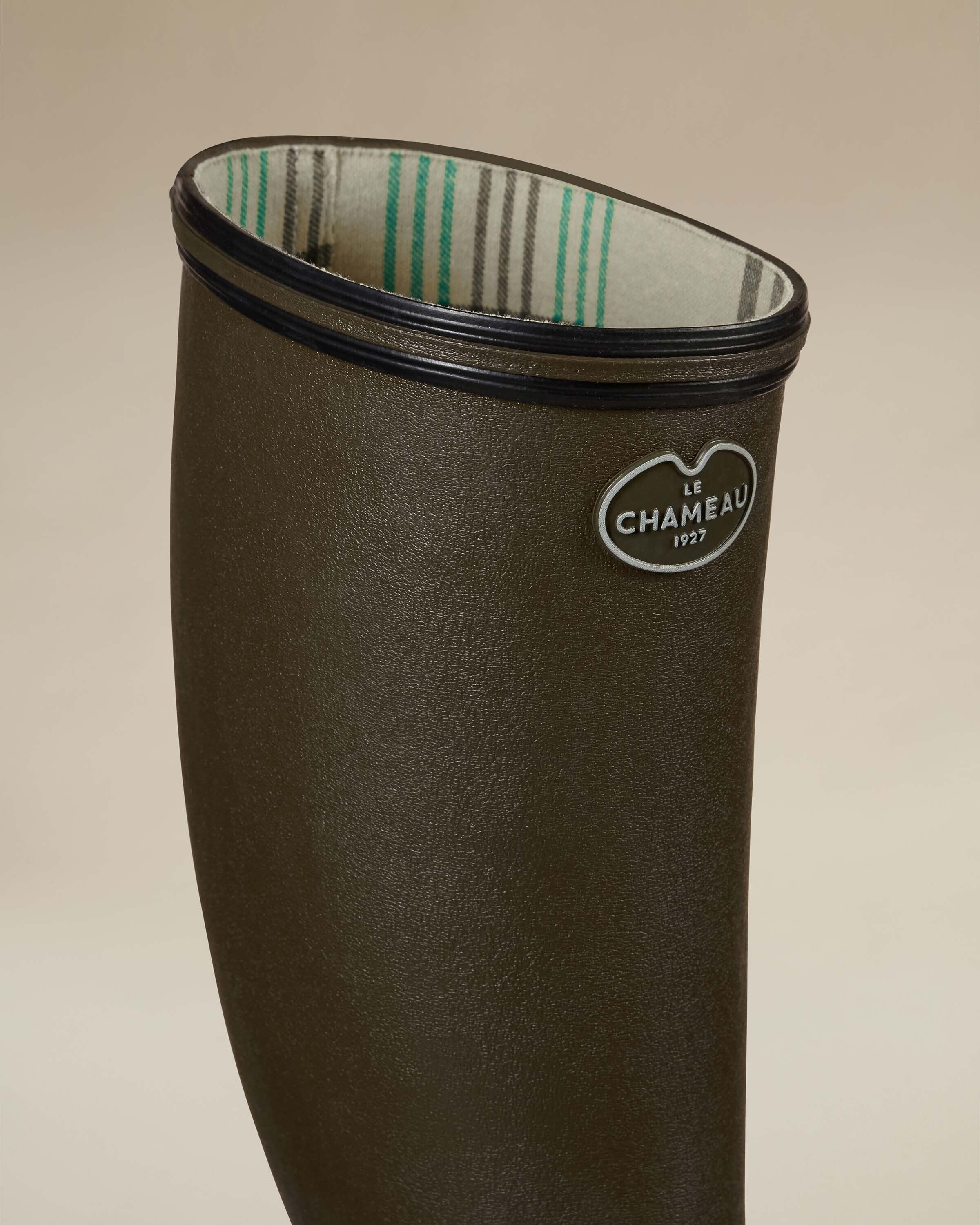 Close-up of the Women's Giverny Jersey Lined Wellington Boot in Chameau Green’s collar showing the Le Chameau logo and jersey lining with green and grey plaid stripes, emphasizing comfort and brand authenticity.