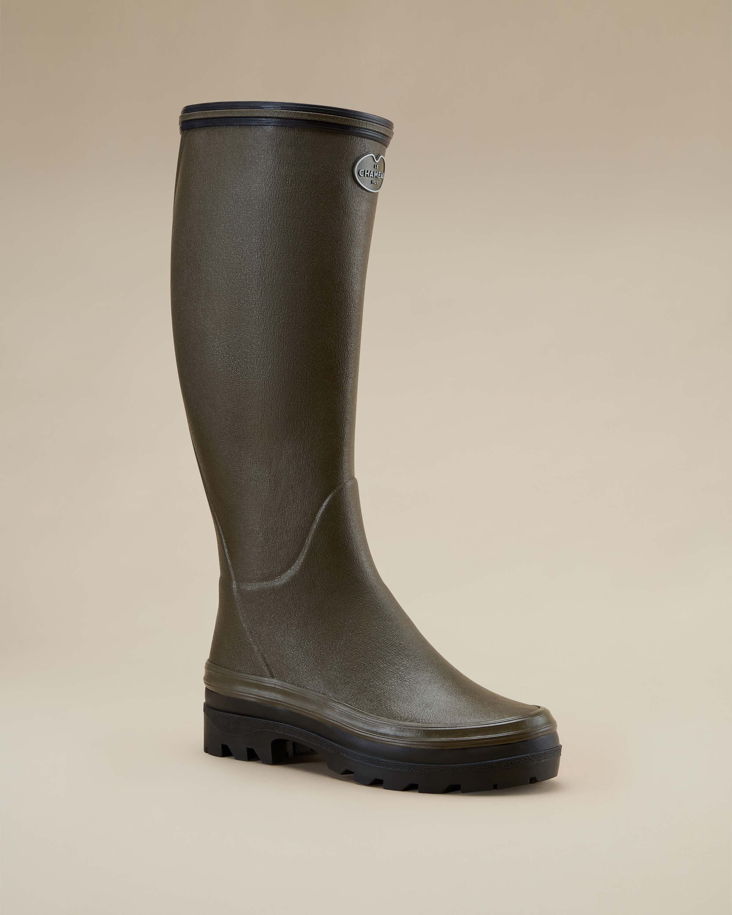 A single Women's Giverny Jersey Lined Wellington Boot in Chameau Green shown in a three-quarter front-facing angle on a beige background, illustrating the ergonomic design and classic countryside style.