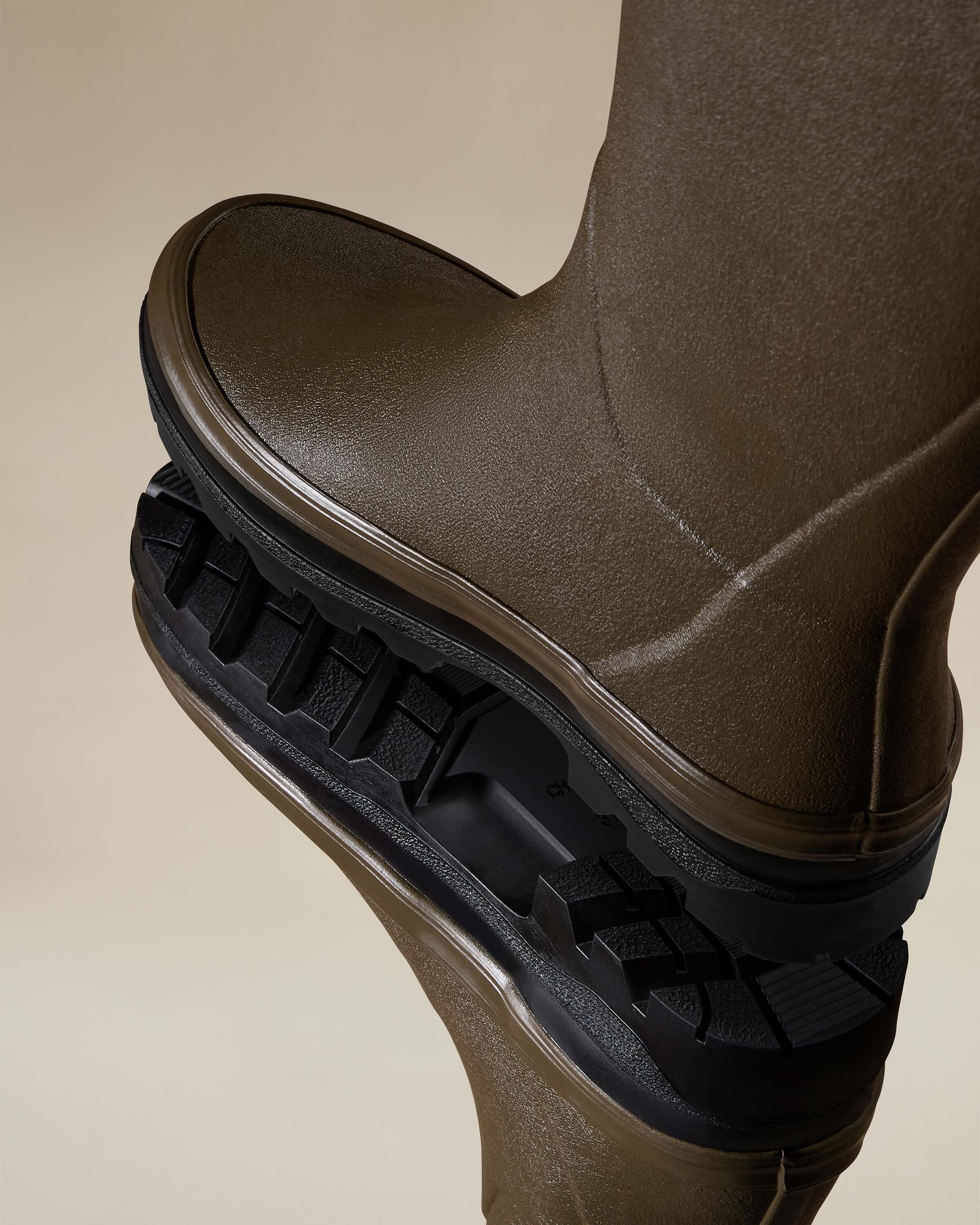 Underside view of the Women's Giverny Jersey Lined Wellington Boot in Chameau Green displaying the rugged black tread pattern designed for enhanced grip and durability, with branded detailing visible in the arch area.