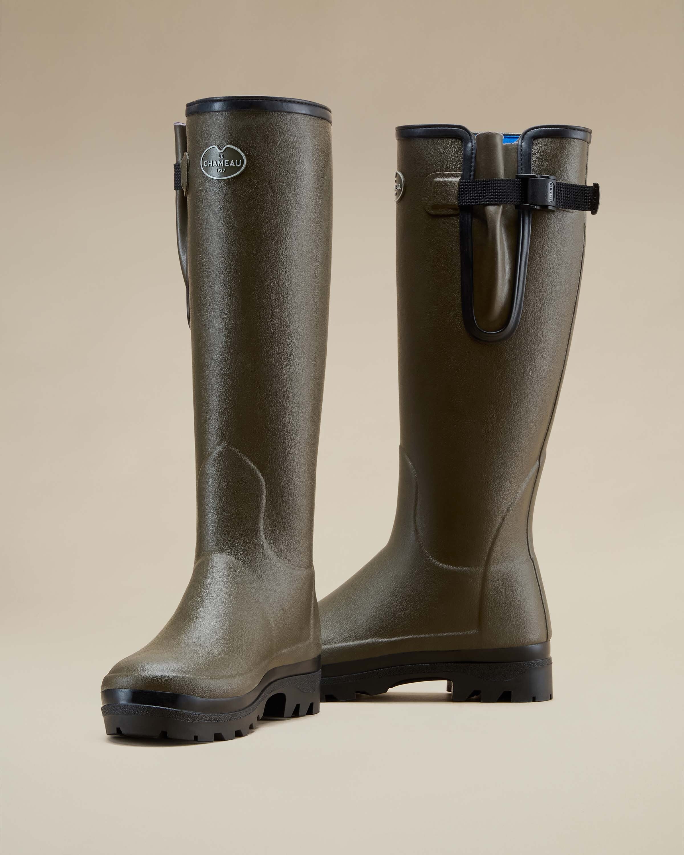 Front three-quarter view of the Women's Vierzonord Neoprene Lined Wellington Boot in Chameau Green as a pair. One boot faces forward while the other is angled slightly outward, clearly showing the deep treaded sole and signature branding badge on the calf.